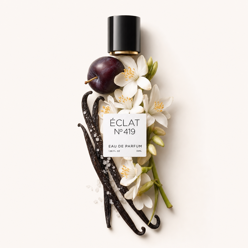Un arrangement élégant de prune mûre, de gousses de vanille, de fleurs blanches et de cristaux de sel marin entoure le capuchon noir ÉCLAT 419 avec étiquette.