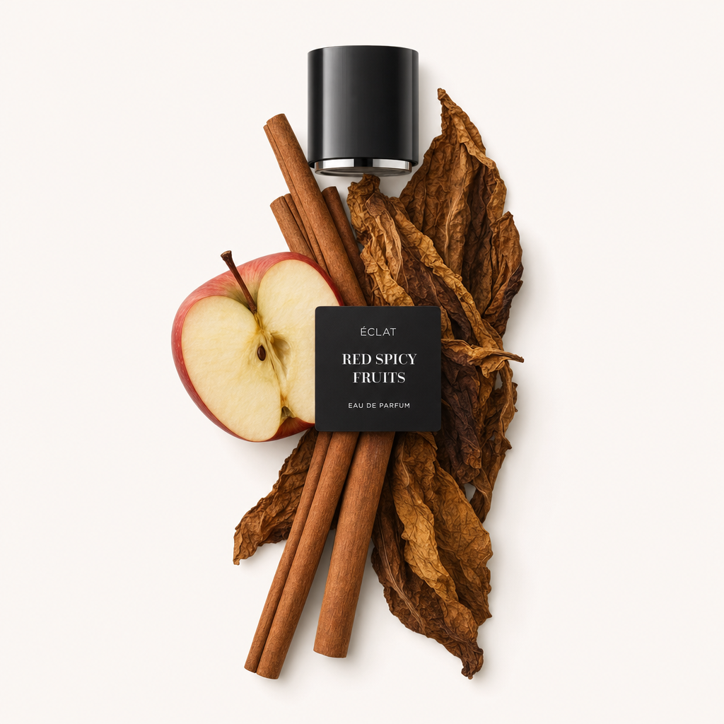 Une composition de bâtons de cannelle, une demi-pomme rouge et de grandes feuilles de tabac séchées entoure le capuchon noir avec étiquette ÉCLAT Red Spicy Fruits.
