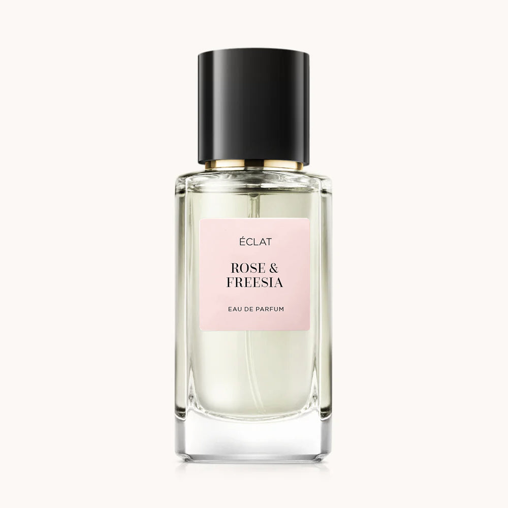Faceted glass bottle with ÉCLAT Rose & Freesia label, featuring a black cap and soft pink label.