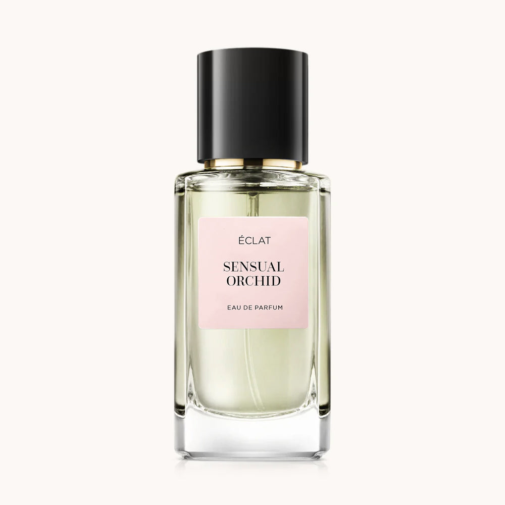 Parfum ÉCLAT Sensual Orchid dans un flacon en verre facetté transparent avec un bouchon noir et une étiquette rose pâle.