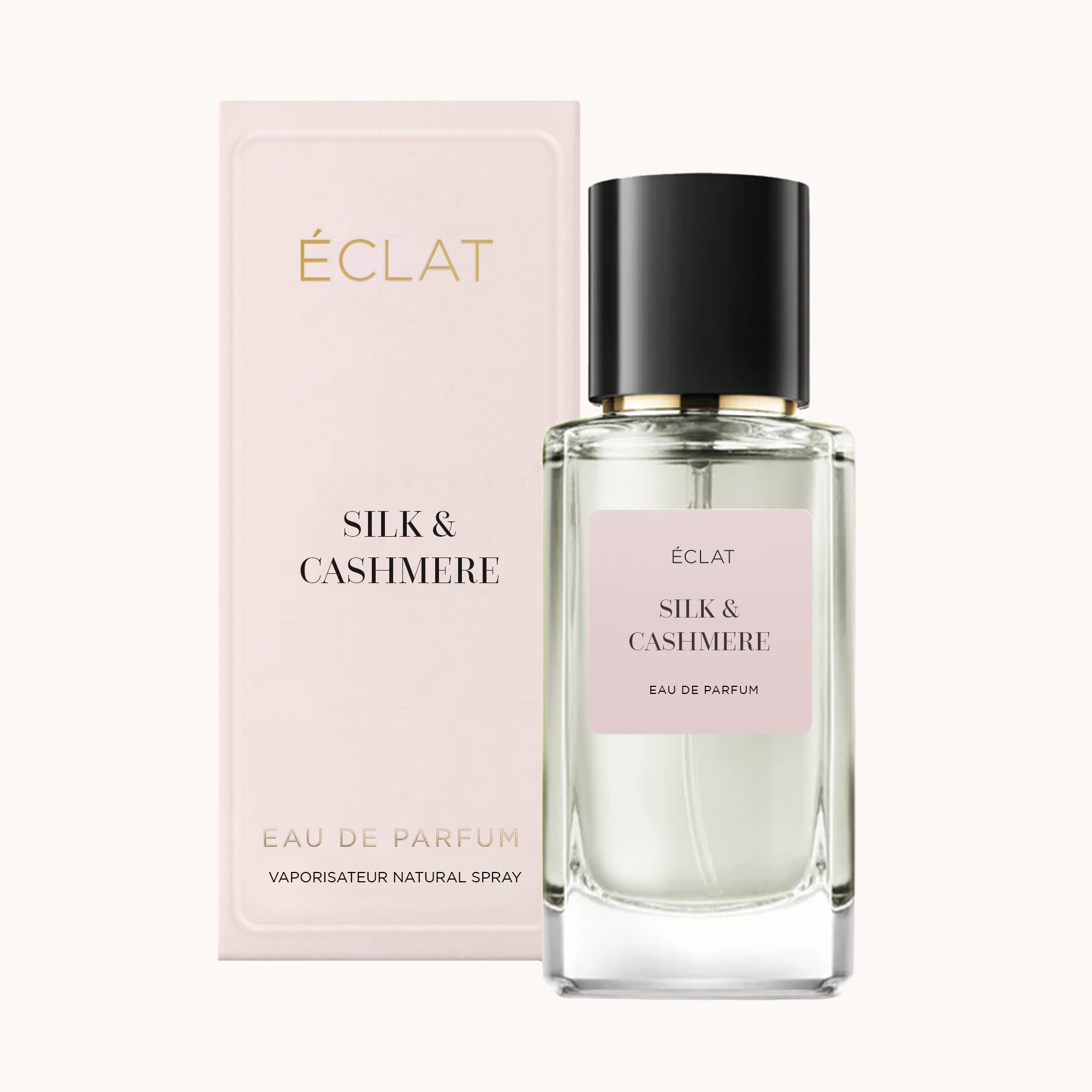 ÉCLAT Silk & Cashmere perfume with a faceted glass bottle and a glossy black cap next to its elegant pastel box.