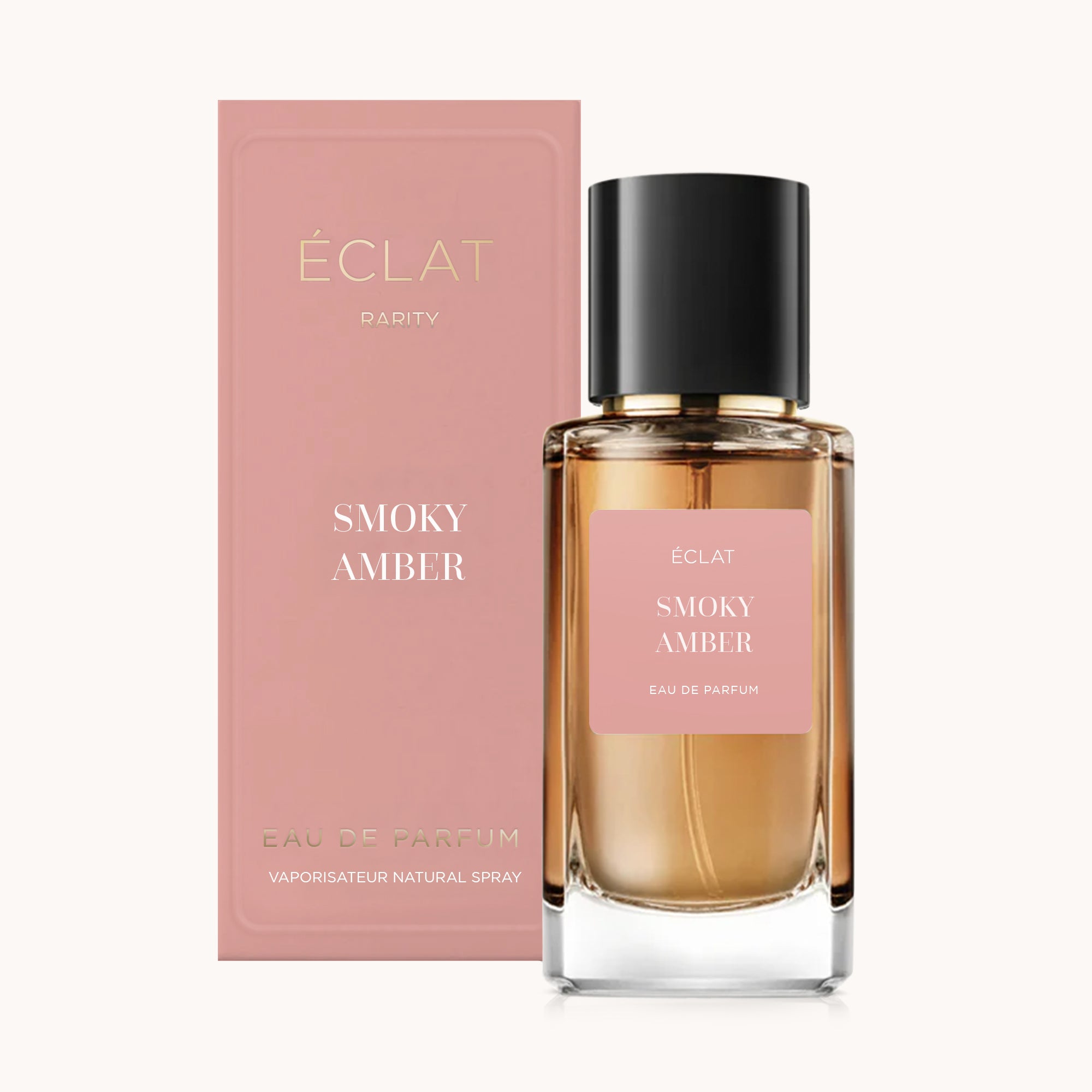 ÉCLAT Smoky Amber parfumfles met roze etiket en zwarte dop, vergezeld van een bijpassende roze doos.