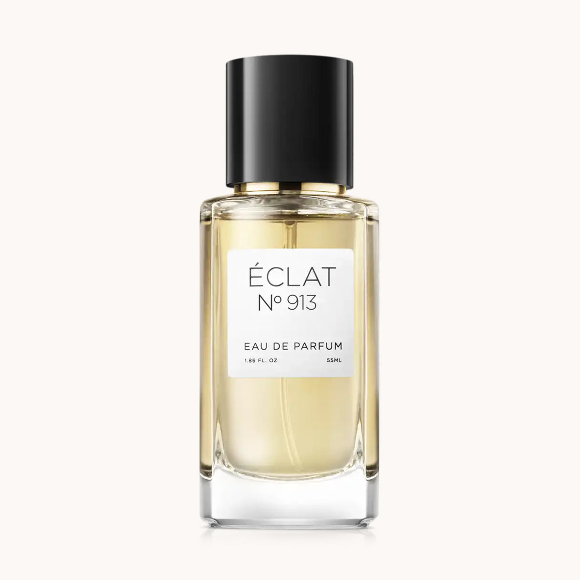 El perfume ÉCLAT Spicy Caramel se presenta en un frasco de vidrio facetado con tapa negra y una elegante etiqueta blanca.
