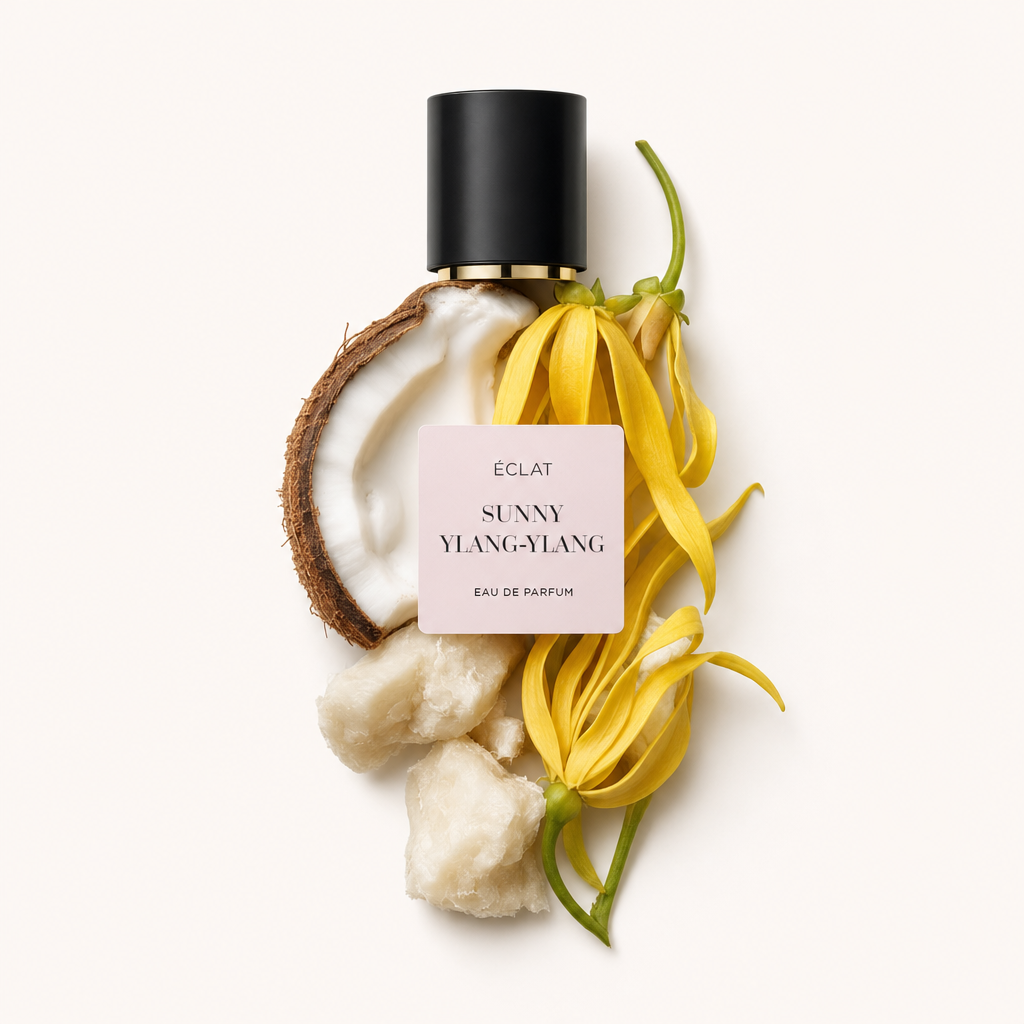 Un arrangement de fleurs d'ylang-ylang fraîches, demi-noix de coco et morceaux de beurre de karité, avec un bouchon noir étiqueté ÉCLAT Sunny Ylang-Ylang.