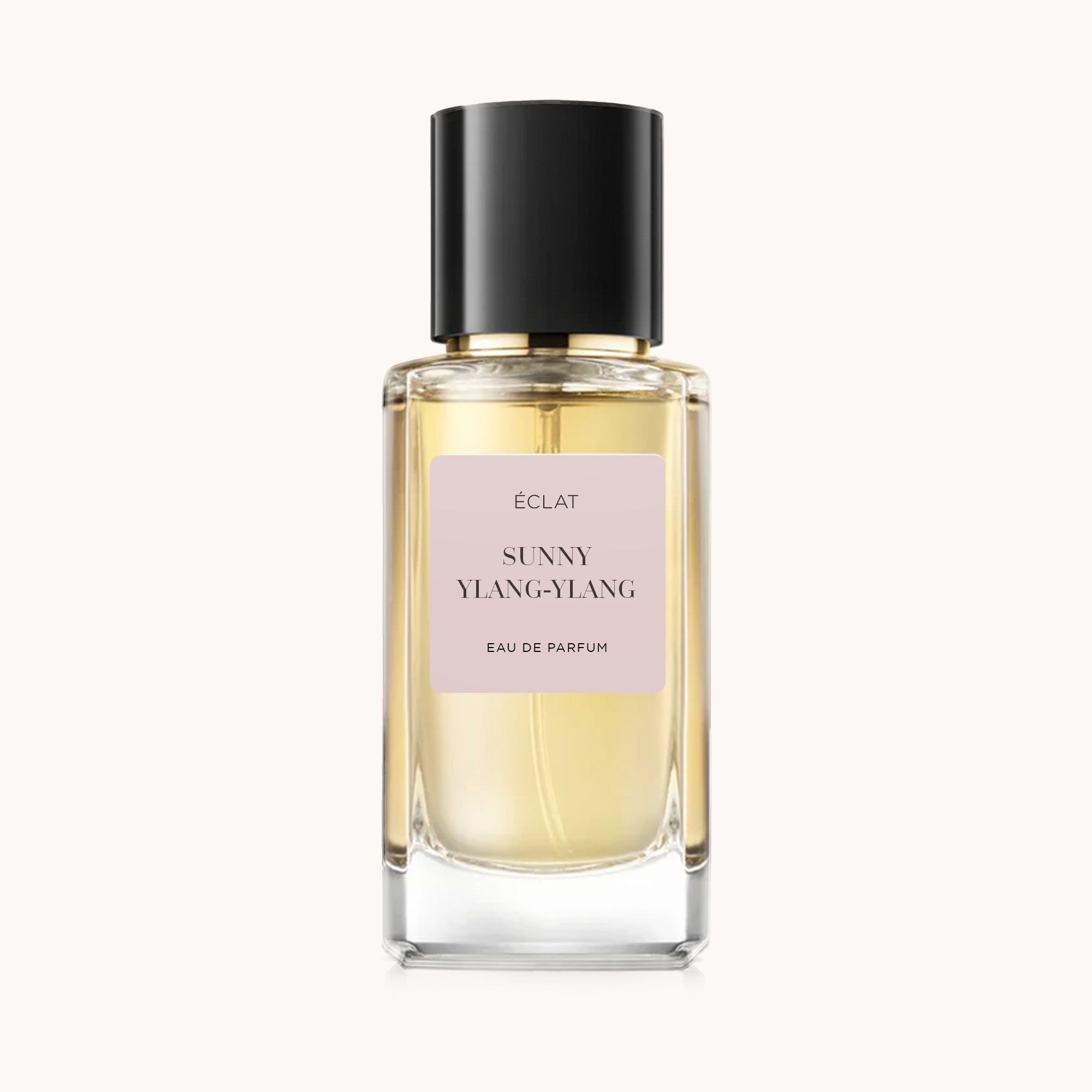 Faceted glass bottle of ÉCLAT Sunny Ylang-Ylang with a beige label and a black glossy cap.