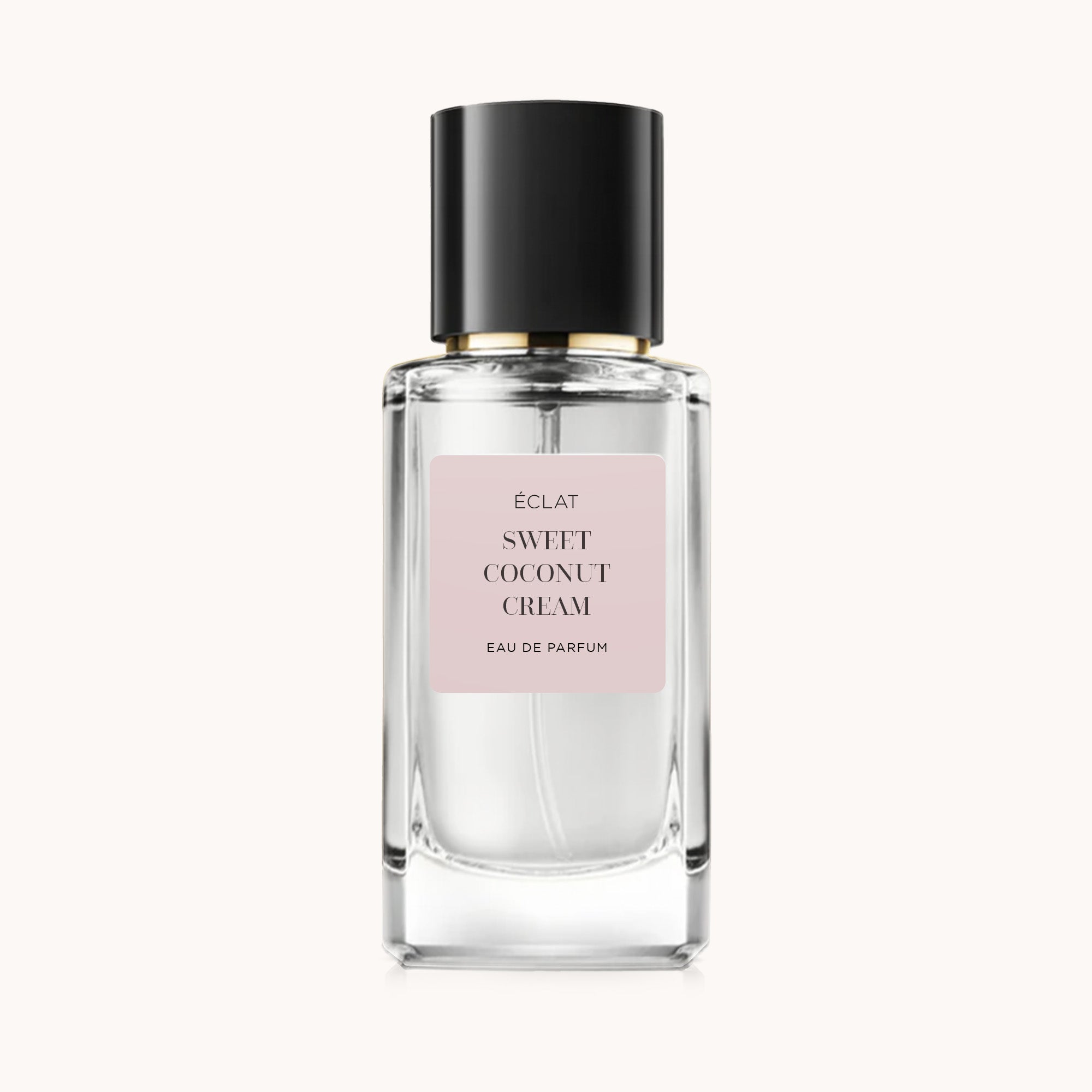 Faceted glass flacon with a black cap and a matte pink label, featuring ÉCLAT Sweet Coconut Cream.