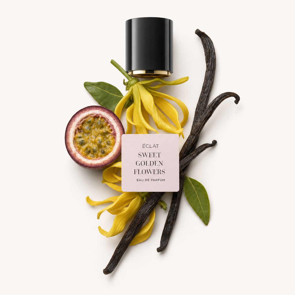 Un capuchon noir avec une étiquette est entouré de fleurs jaunes, d’un fruit de la passion coupé, de feuilles vertes et de gousses de vanille représentant ÉCLAT Sweet Golden Flowers.