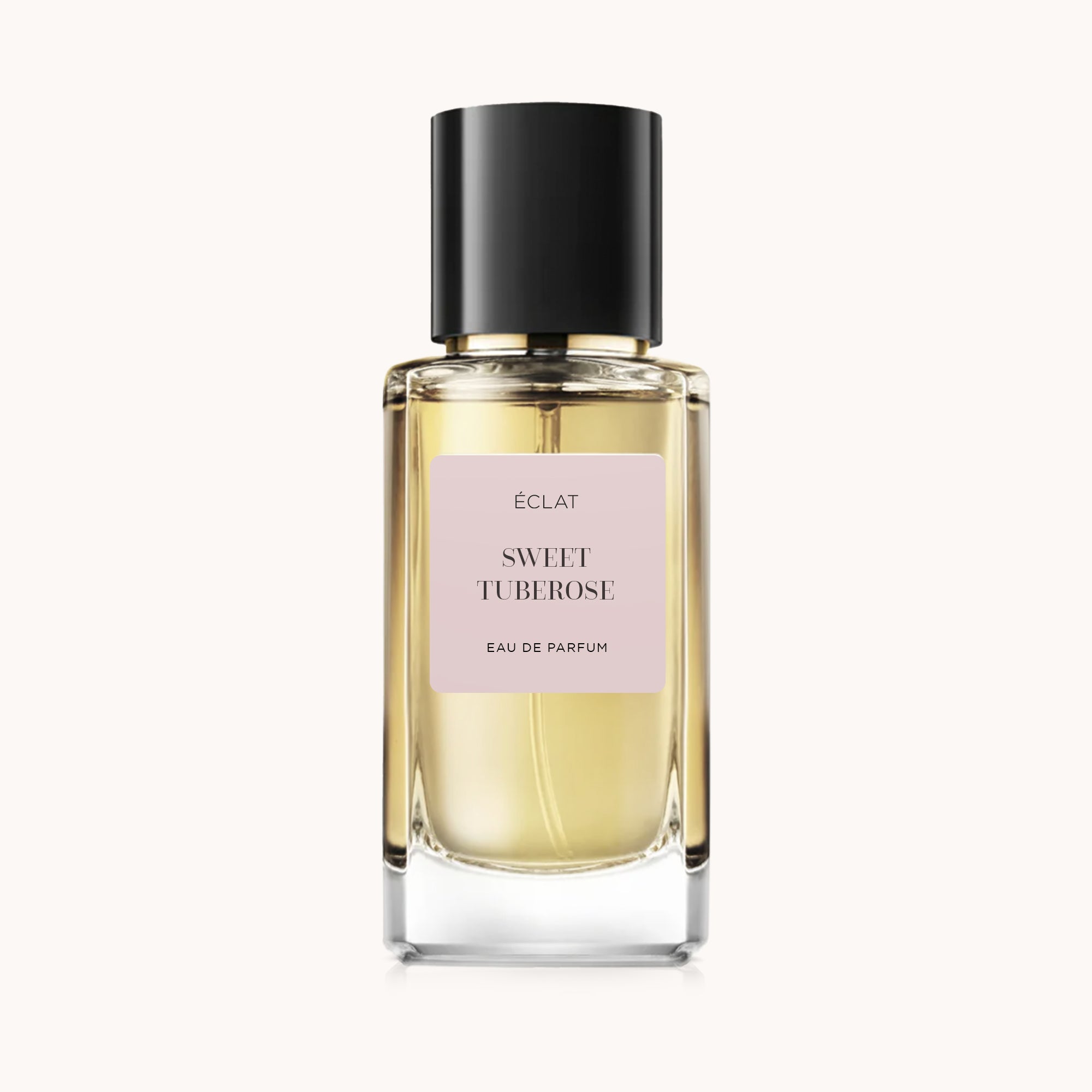 Το άρωμα ÉCLAT Sweet Tuberose σε γυάλινο μπουκάλι με μαύρο καπάκι και ροζ ετικέτα.