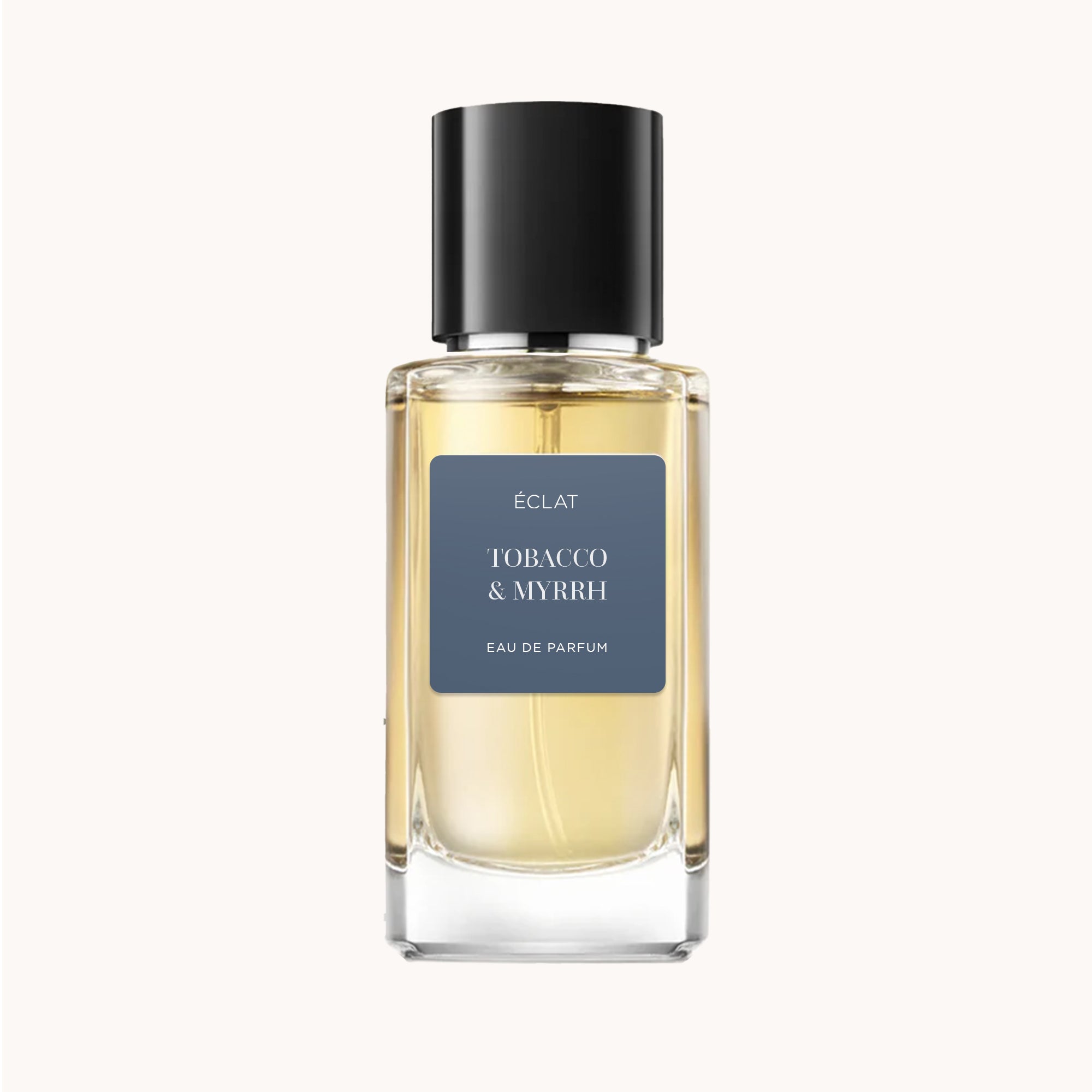 ÉCLAT Tobacco & Myrrh in a clear glass flacon with a black cap and a matte blue label.