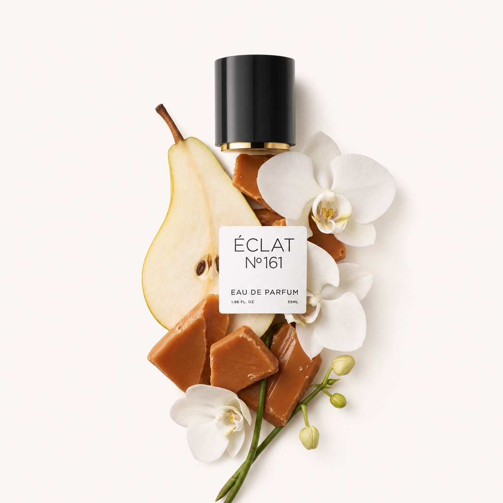 Une composition de morceaux de caramel, une tranche de poire et des fleurs d'orchidées blanches est élégamment disposée à côté d'un bouchon noir avec une étiquette portant le texte ÉCLAT Toffee & Patchouli.