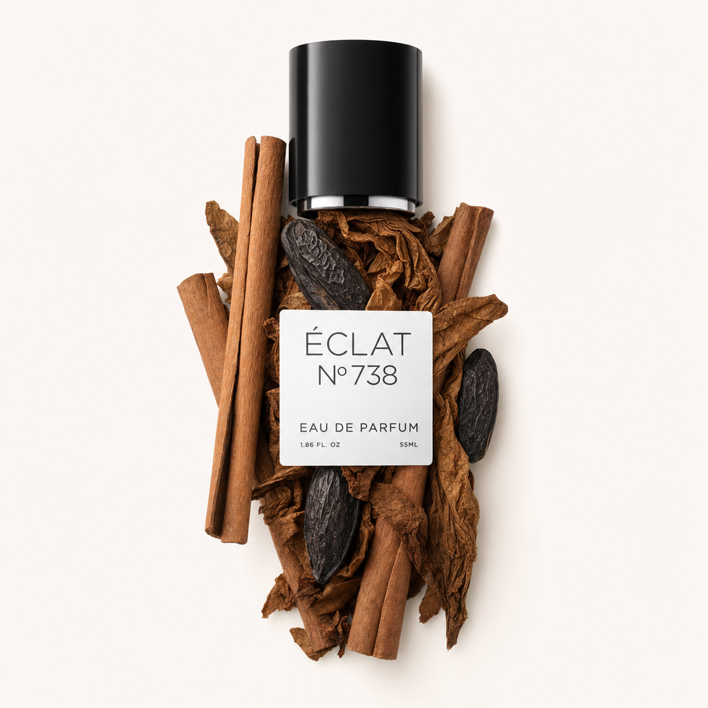 Uma tampa preta com etiqueta ÉCLAT Tonka Bean & Cinnamon está colocada sobre um arranjo de paus de canela e favas tonka.