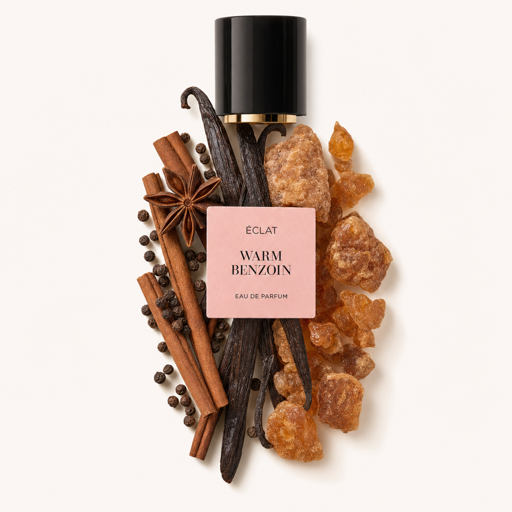 Un arreglo de vainas de vainilla, ramas de canela, anís estrellado, granos de pimienta negra y resina de benzoína rodea una tapa negra con etiqueta ÉCLAT Warm Benzoin.