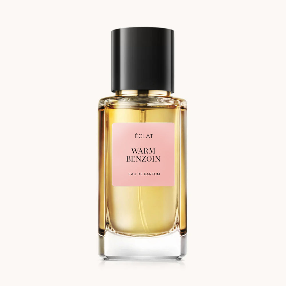 Frasco de vidrio facetado de ÉCLAT Warm Benzoin con tapa negra y etiqueta rosa.