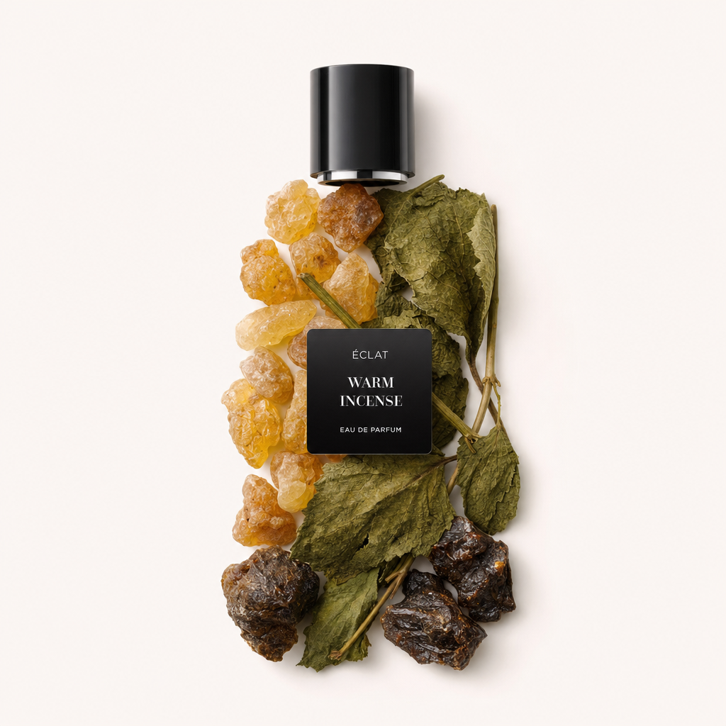 Un arrangement de résine d'ambre, de feuilles séchées et de composants d'encens sombres, surmonté d'un bouchon noir étiqueté ÉCLAT Warm Incense.