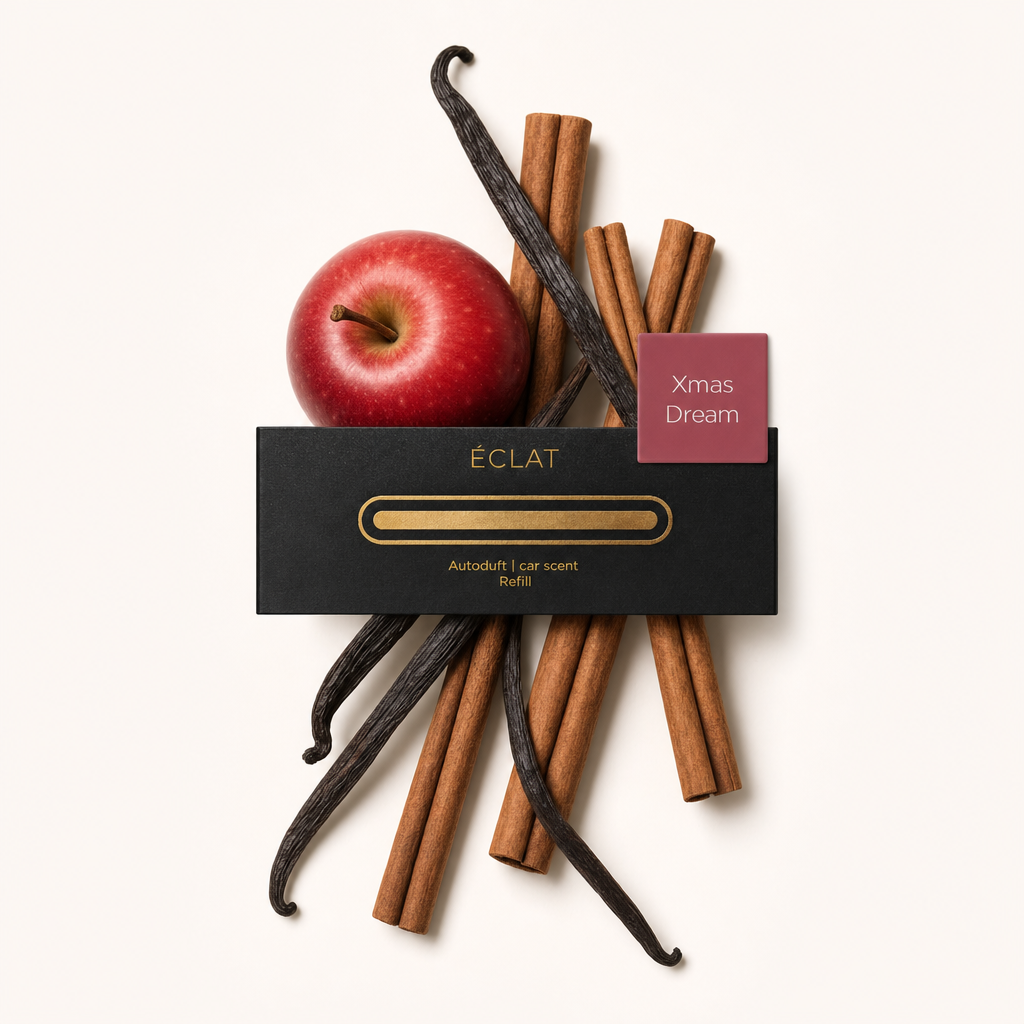 Un arrangement de bâtons de cannelle parfumés, de gousses de vanille et d'une pomme rouge, entourant le capuchon noir original ÉCLAT avec étiquette.