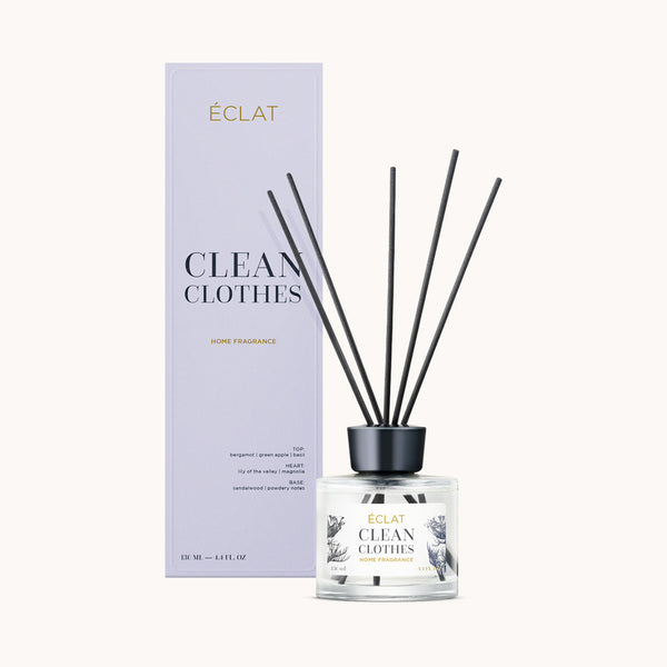 ÉCLAT Clean Clothes Palitos de Fragancia en un frasco de vidrio transparente con cierre negro junto a una caja pastel.